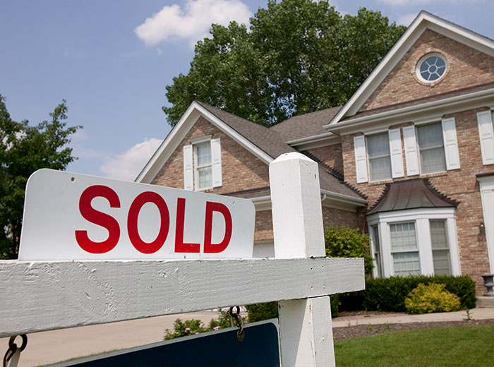 An attractive home with a SOLD sign in the front yard