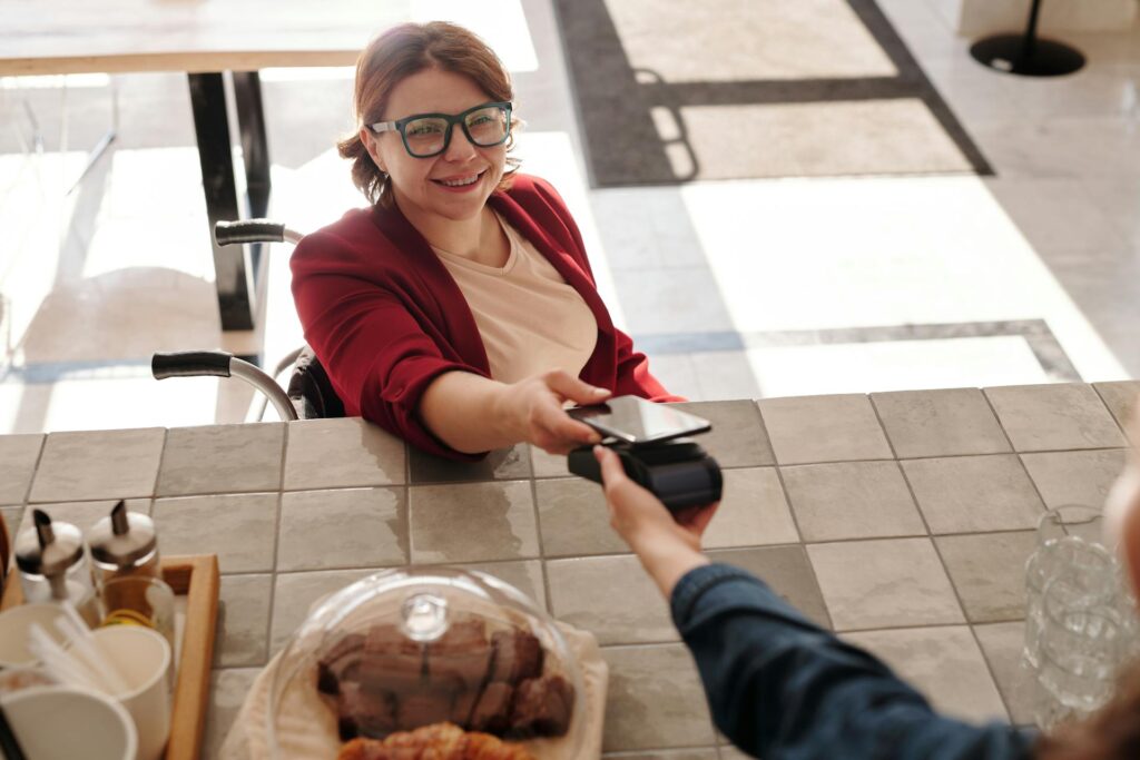 A woman paying a merchant with her phone