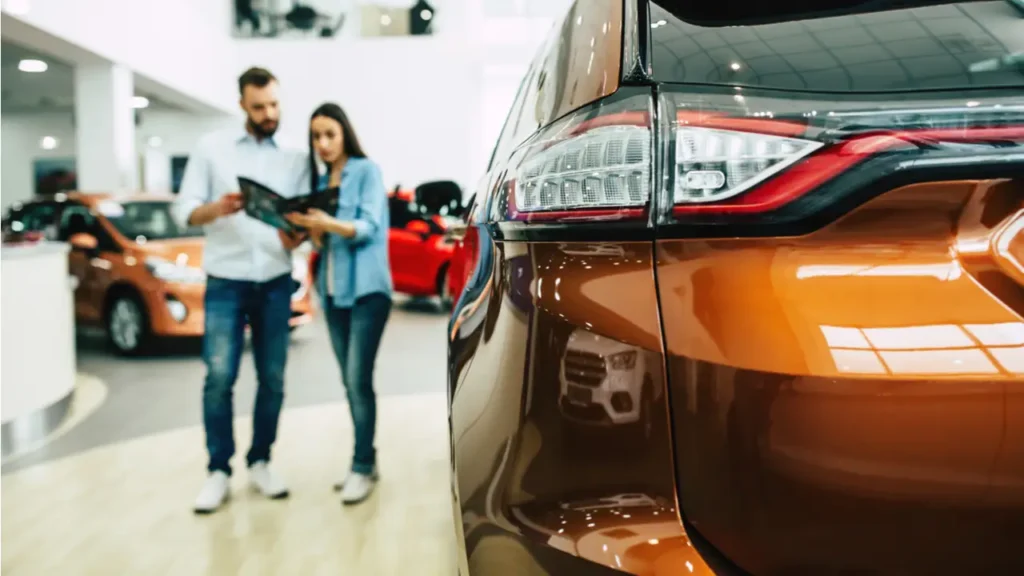 consumer loan photo depicted by two people blurred beside a new auto